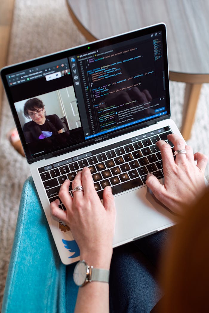 Crafting Captivating Headlines: Your awesome post title goes here Person coding on a laptop during a video conference, showcasing remote work.